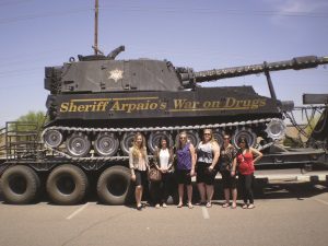 Students stand next to a tank