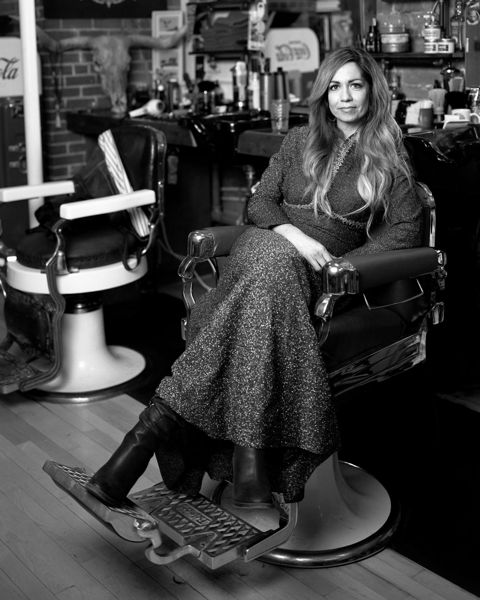 Black and white portrait of a woman in a barbershop