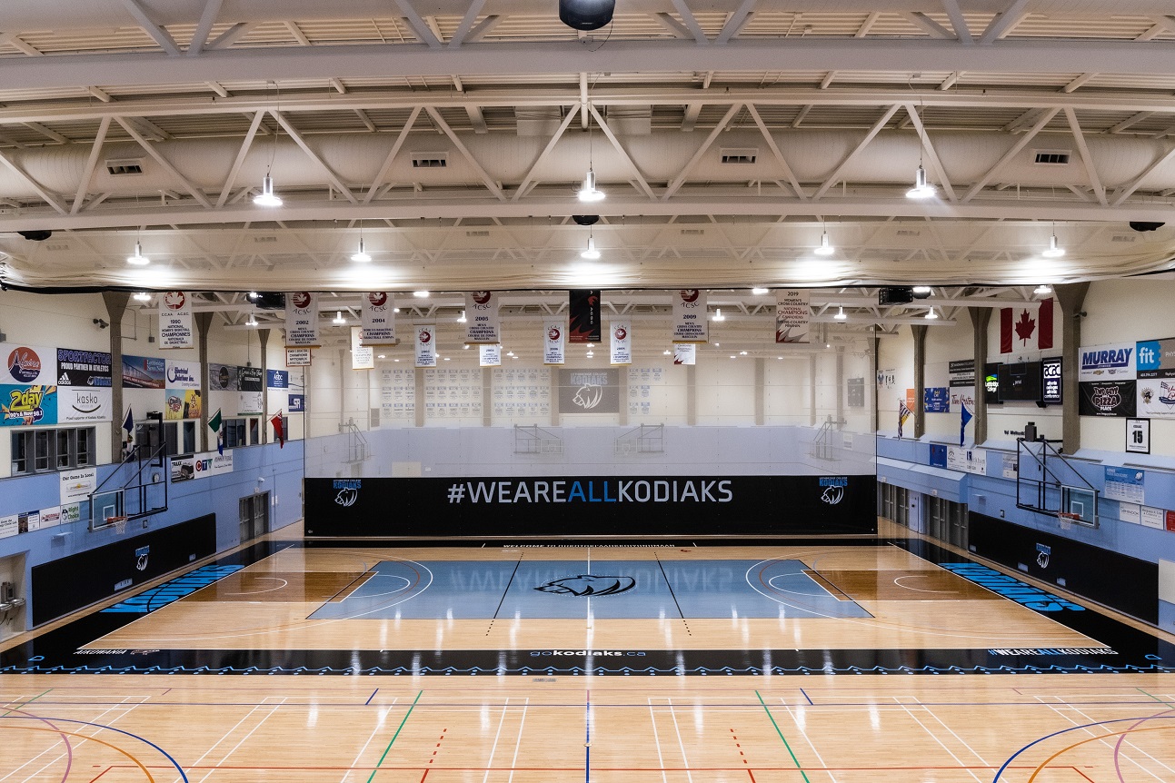 a wide shot of a gymnasium floor with blue stain in the centre