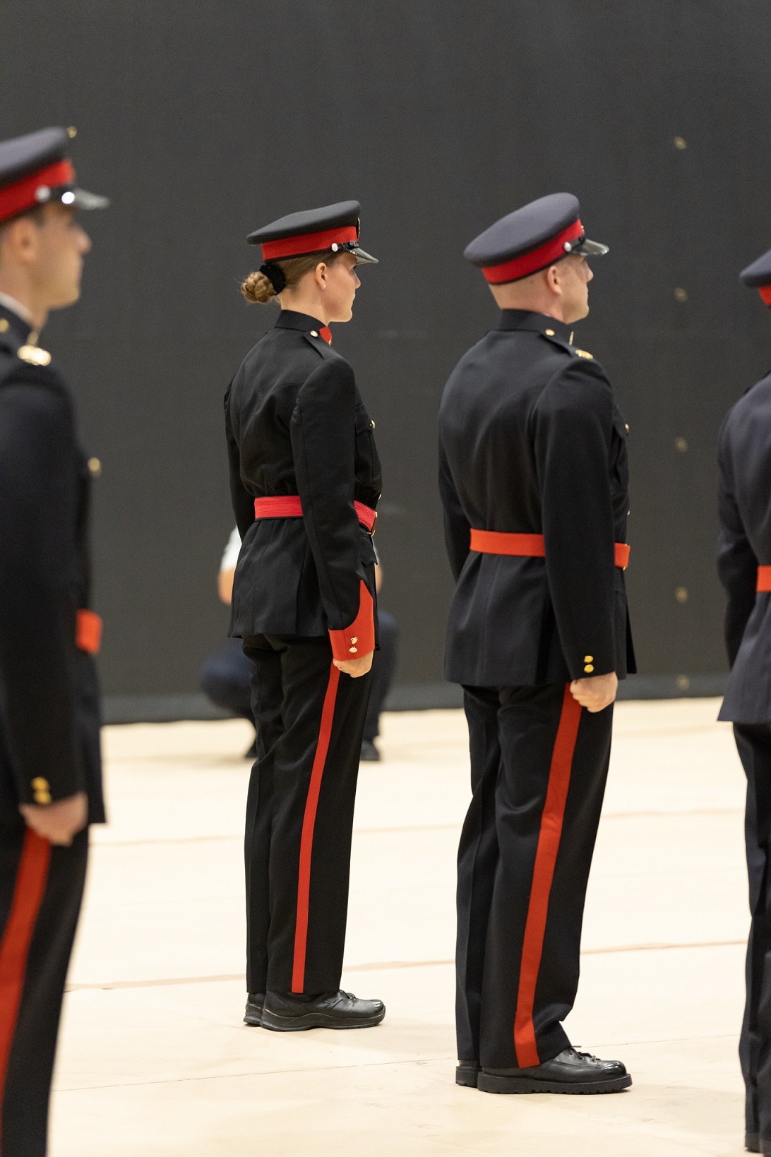 A group of police cadet graduates stand in line in uniform