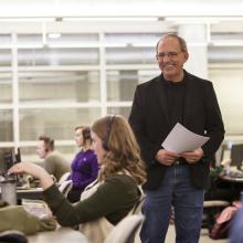 Research Chair Faron Ellis stands behind a student working in the Citizen Society Research Lab.