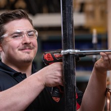 a man wearing safety glasses works with tools