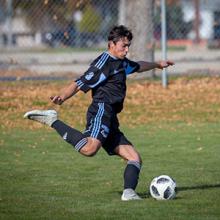 A Kodiaks men's soccer player strikes the ball in ACAC action.