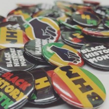 a pile of Black History Month buttons sitting on a table