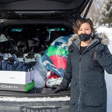 Indigenous Services manager Shanda Webber with clothing donated by Lethbridge College employees for those in need.