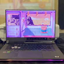 A laptop is open showing animated train scenes