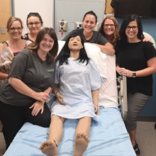 Faculty members from Lethbridge College's SPHERE team pose with a training mannequin.